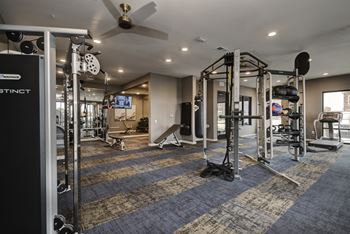 a gym with weights and cardio equipment and a ceiling fan  at Watermark on Twenty Mile, Parker, Colorado